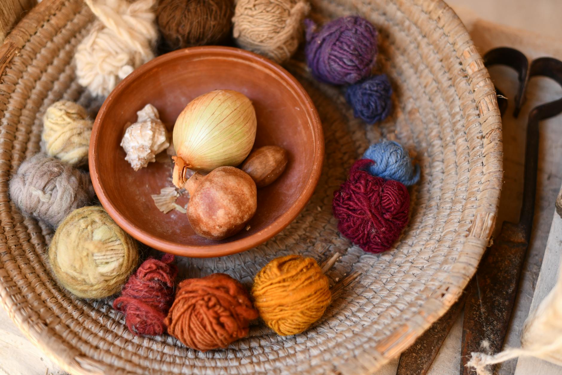 onion in bowl between yarns of wool