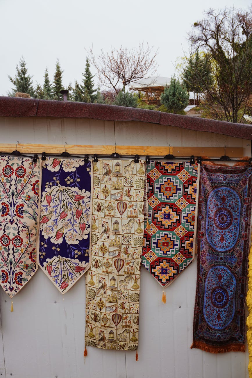 a row of colorful rugs hanging on a wall